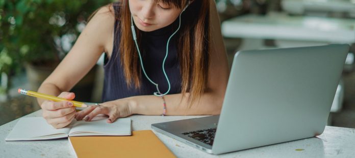 Studentica bilježi informacije uz prijenosno računalo